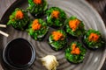 Sushi maki rolls with crab, seaweed salad and flying fish roe on a plate with chopsticks, soy sauce, wasabi and ginger Royalty Free Stock Photo
