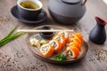 Sushi maki rolls with salmon, avocado, cucumber, flying fish roe on a plate with chopsticks, soy sauce, wasabi and Royalty Free Stock Photo