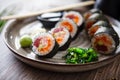 Sushi maki rolls with tuna, flying fish caviar, crab, avocado on a plate with chopsticks, soy sauce, wasabi and ginger Royalty Free Stock Photo