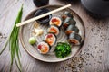 Sushi maki rolls with tuna, flying fish caviar, crab, avocado on a plate with chopsticks, soy sauce, wasabi and ginger Royalty Free Stock Photo