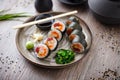 Sushi maki rolls with tuna, flying fish caviar, crab, avocado on a plate with chopsticks, soy sauce, wasabi and ginger Royalty Free Stock Photo