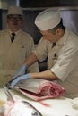 Sushi master slicing a tuna