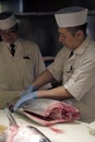 Sushi master slicing a tuna