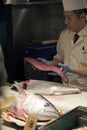 Sushi master slicing a tuna