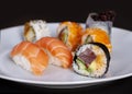 Sushi menu with salmon, rice and tuna rolls on a plate with black background. Japanese food. Close up with selective focus Royalty Free Stock Photo