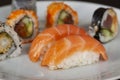 Sushi menu with salmon, rice and tuna rolls on a plate with black background. Japanese food. Close up with selective focus Royalty Free Stock Photo