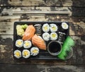 Sushi menu set in black transport box on dark wooden background, top view Royalty Free Stock Photo