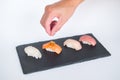 Four sushi pieces served on black slate on the white background.