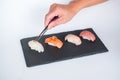 Sushi Nigiri served on black tray.