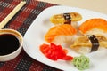 Sushi with omelet with eel and with salmon and soy sauce with ginger and wasabi on black and red bamboo mat close up. Royalty Free Stock Photo