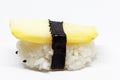 A sushi piece with yellow radish on white background