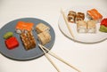 Sushi on the plates with chopsticks on white wooden background. Romantic dinner in Japanese style. Salmon, wasabi and ginger. Royalty Free Stock Photo