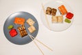 Sushi on the plates with chopsticks on white wooden background. Romantic dinner in Japanese style. Salmon, wasabi and ginger. Royalty Free Stock Photo