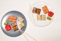 Sushi on the plates with chopsticks on white wooden background. Romantic dinner in Japanese style. Salmon, wasabi and ginger. Royalty Free Stock Photo