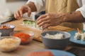 Sushi preparation close up on a male chief& x27;s hands rolling vegan roll. Vegan menu