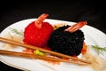 Sushi, red and black fish eggs with chopsticks..