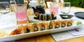 sushi restaurant. Outside table set up and dish presentation. Raw salmon sushi plate with drinks. Royalty Free Stock Photo