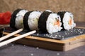 Sushi of rice, cucumber fish and cheese on a serving board with chopsticks Royalty Free Stock Photo