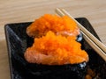 Sushi rice wrapped in seaweed and shrimp egg on a wooden table. Royalty Free Stock Photo