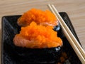 Sushi rice wrapped in seaweed and shrimp egg on a wooden table. Royalty Free Stock Photo