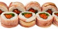 Sushi roll with bacon and salmon on a white background, ingredients seared bacon, salmon, green onions, flying fish roe, Iceberg Royalty Free Stock Photo