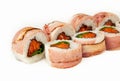 Sushi roll with bacon and salmon on a white background, ingredients seared bacon, salmon, green onions, flying fish roe, Iceberg Royalty Free Stock Photo