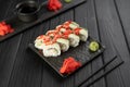 Sushi roll with caviar tobico, avocado and cream cheese on black background. Sushi menu. Japanese food concept. Royalty Free Stock Photo