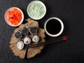 Sushi roll with crab meat on a wooden board on a black background.