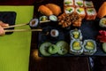 Sushi roll eating with chopstick. Sushi set restaurant. Black background. Royalty Free Stock Photo