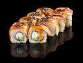 Sushi roll with eel, cheese, cucumber, unagi sauce and sesame isolated on black background with reflection Royalty Free Stock Photo