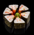 Sushi roll in the form of triangle with salmon, shrimp and avocado on black background with reflection