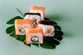 Sushi Roll Philadelphia with Salmon Cream Cheese on Fake Monstera Leaf on Green Background Sushi Menu Japanese Food
