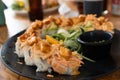 Sushi roll plate with breaded prawn and sauce on top Royalty Free Stock Photo