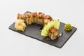 Sushi roll of red dragon in black stone plate isolated on white Royalty Free Stock Photo
