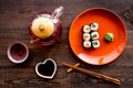 Sushi roll with salmon and avocado on plate with soy sauce, chopstick, wasabi on wooden table background top view Royalty Free Stock Photo