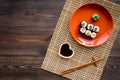 Sushi roll with salmon and avocado on plate with soy sauce, chopstick, wasabi on wooden table background top view Royalty Free Stock Photo