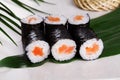 Sushi roll salmon chives mini kappa maki in the still life on a tropical leaves