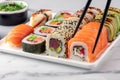 Sushi roll with salmon and chopsticks. Sushi rolls set are served on a white plate. Royalty Free Stock Photo