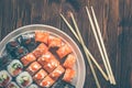 Sushi roll with salmon, cucumber, avocado, red caviar with chopsticks. Sushi menu. Japanese food. Close up, on bamboo napkin Royalty Free Stock Photo