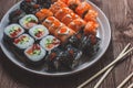 Sushi roll with salmon, cucumber, avocado, red caviar with chopsticks. Sushi menu. Japanese food. Close up, on bamboo Royalty Free Stock Photo