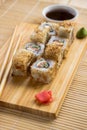 Sushi roll with salmon, cucumber and tuna skin on a wooden board Royalty Free Stock Photo