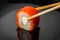 Sushi roll with salmon on a dark background, close-up