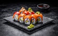 Sushi roll with salmon, smoked eel, avocado, cream cheese on a black background. Sushi menu. Japanese food. Royalty Free Stock Photo