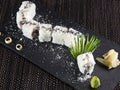 Sushi roll with sesame on a black stone plate, close up photo on dark background Royalty Free Stock Photo