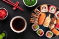 Sushi roll set on a blue round plate, wakame chuka salad, soy sauce in a bowl and ginger on the side. Royalty Free Stock Photo