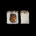 Sushi. Roll with smoked salmon, lola ross salad, cucumber and fried sesame, isolated in black background Royalty Free Stock Photo