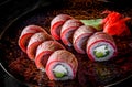 Sushi roll with tuna, avocado, cream cheese, cucumber, rice in plate on black wooden table Royalty Free Stock Photo