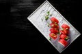 Sushi roll with tuna, cream cheese, cucumber, rice in plate on black wooden table Royalty Free Stock Photo