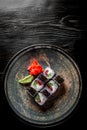 Sushi roll with tuna, cucumber, cream cheese, rice in plate on black wooden table Royalty Free Stock Photo