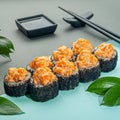 Sushi roll Volcano with salmon, pineapple and cream cheese. With spicy sauce. Sprinkled with black masago caviar. Decorated with Royalty Free Stock Photo